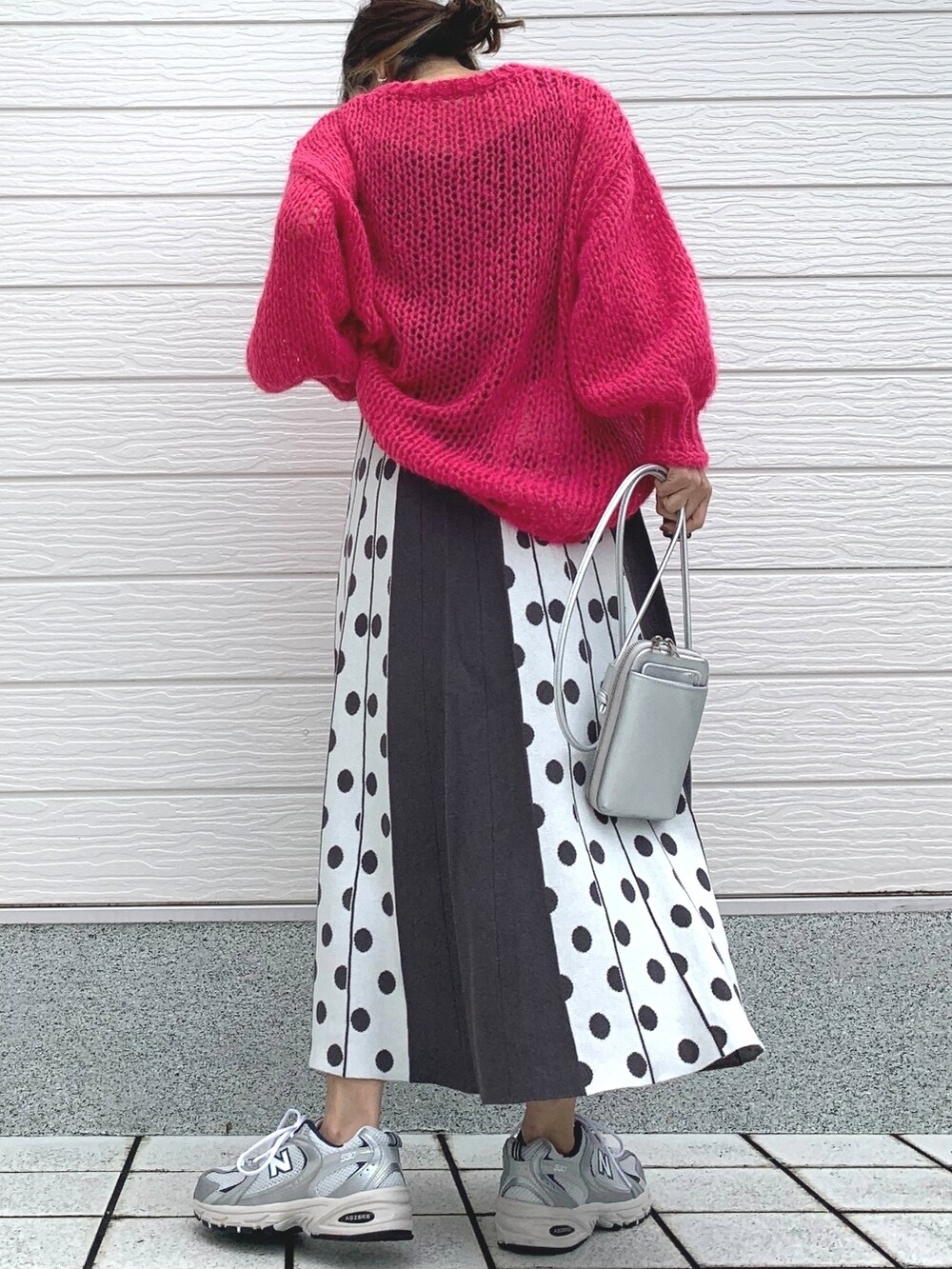 シルバー系のスニーカー、シルバー系のショルダーバッグ、ピンク系のニット/セーターを着用したレディースの冬コーディネートの3枚目の写真