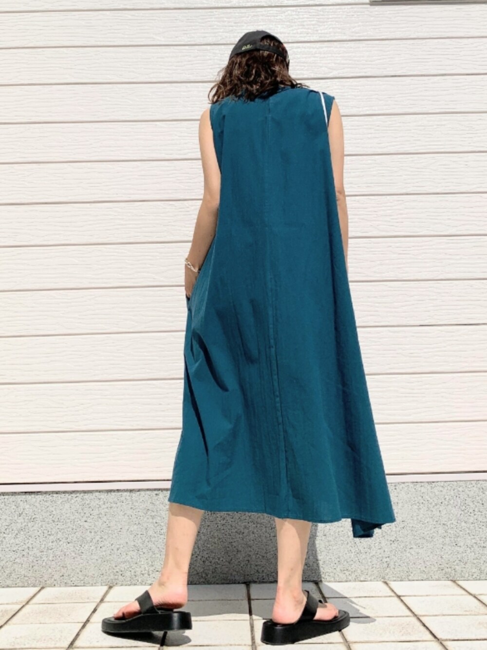 グリーン系のワンピース、グレー系のキャップを着用したレディースの夏コーディネートの3枚目の写真