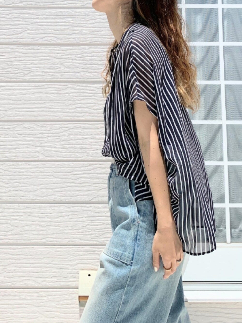 シルバー系のショルダーバッグ、ブルー系のデニムパンツ、ブルー系のシャツ/ブラウスを着用したレディースの夏コーディネートの4枚目の写真