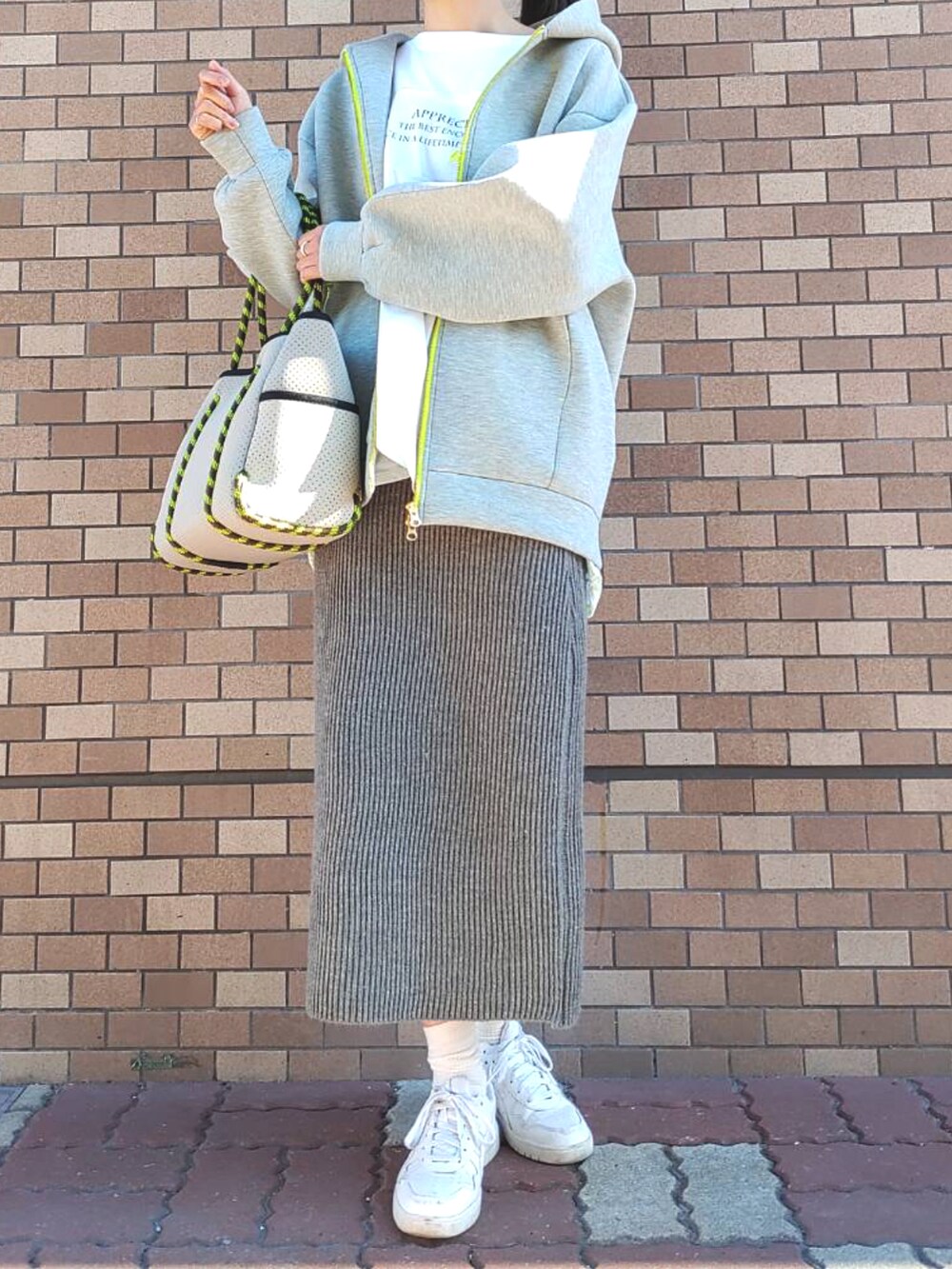 ホワイト系のスニーカー、グレー系のトートバッグ、グレー系のその他アウターを着用したレディースの冬コーディネートの2枚目の写真