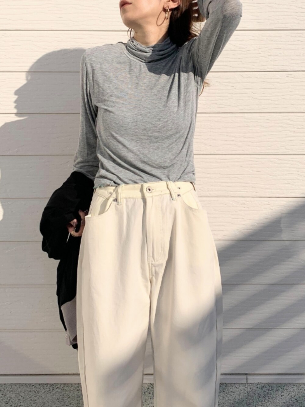 ホワイト系のデニムパンツ、グレー系のTシャツ/カットソー、ブラック系のカーディガン/ボレロを着用したレディースの秋コーディネートの4枚目の写真