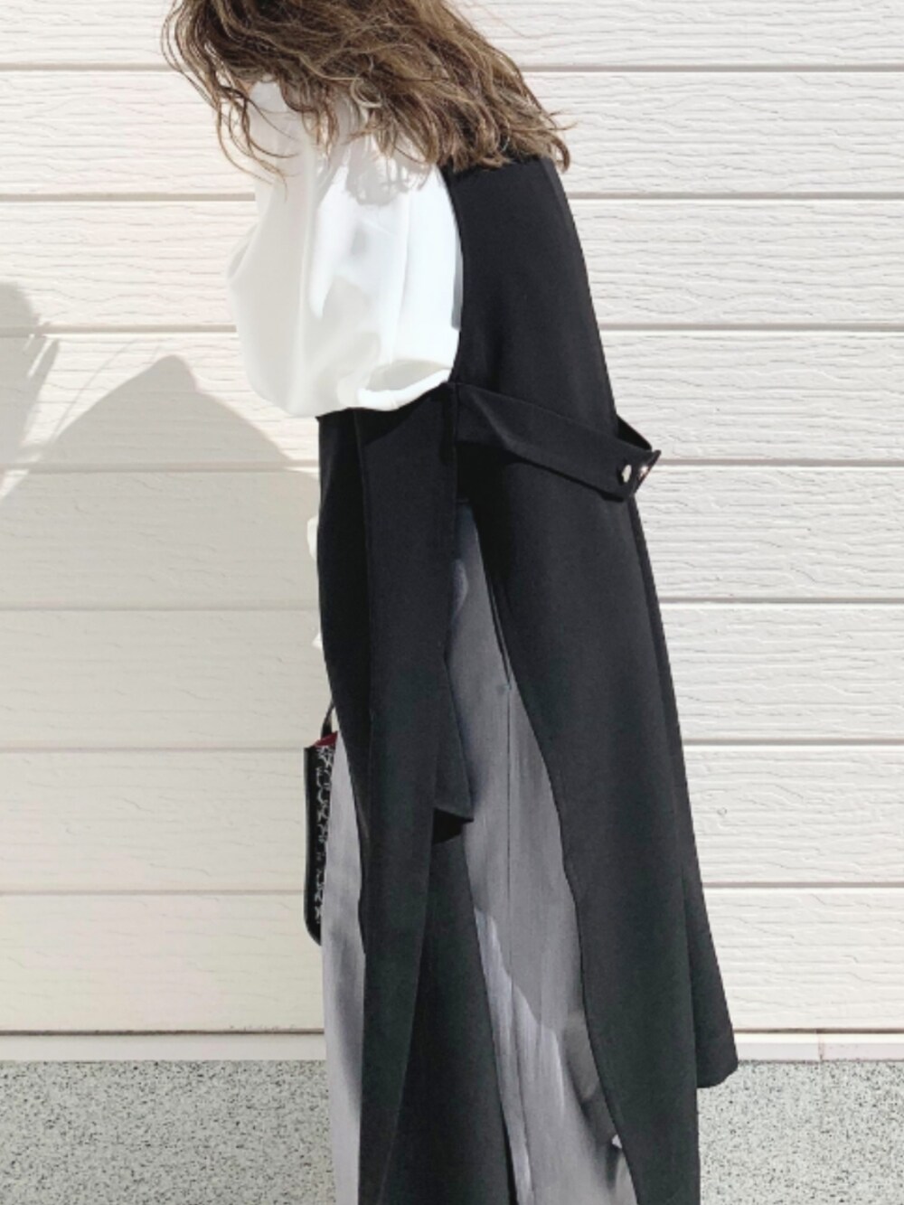 ブラック系のショルダーバッグ、グレー系のスラックス、ホワイト系のシャツ/ブラウスを着用したレディースの春コーディネートの4枚目の写真