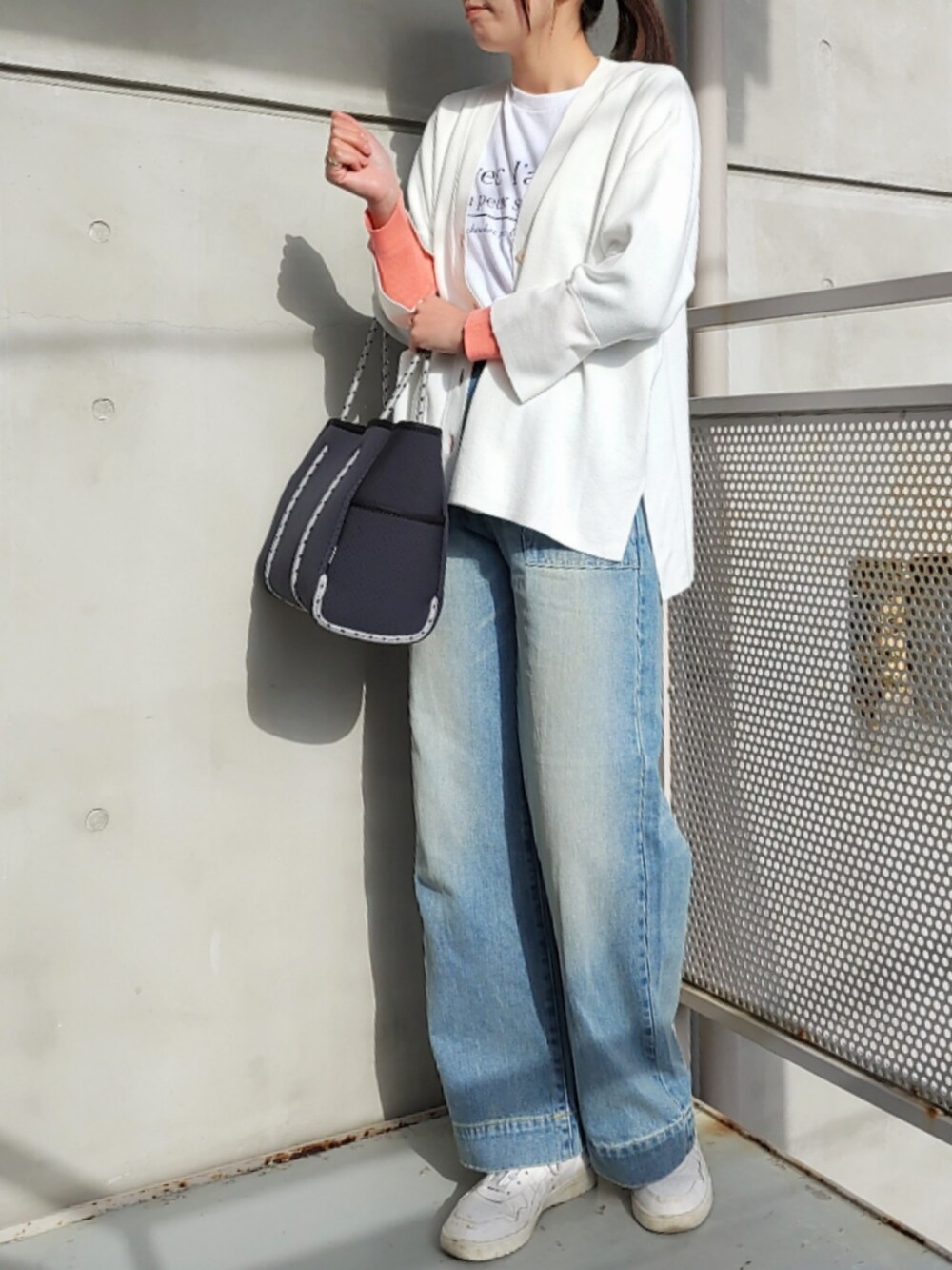 ブルー系のトートバッグ、ブルー系のデニムパンツ、ホワイト系のスニーカーを着用したレディースの冬コーディネートの2枚目の写真