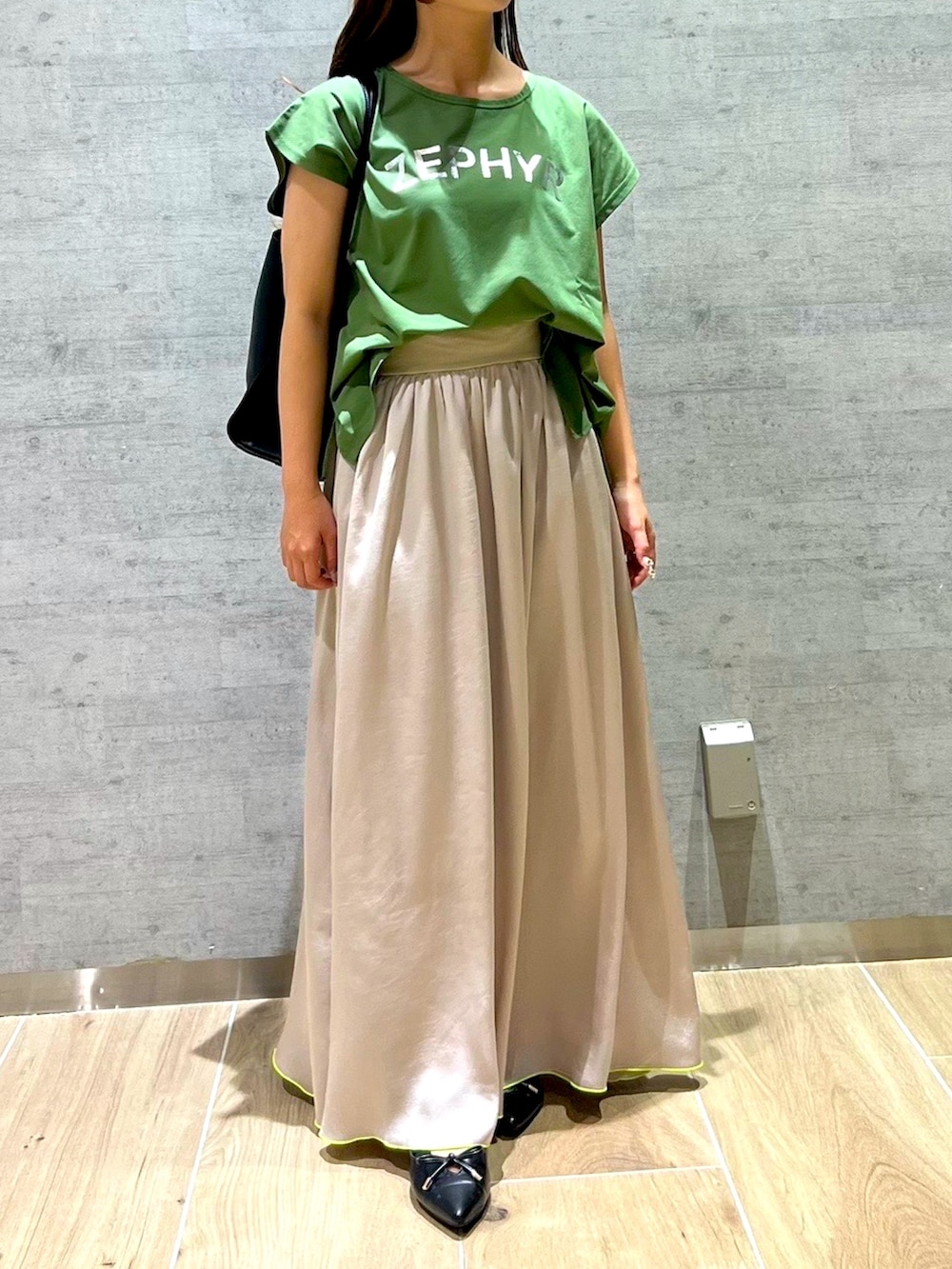 ベージュ系のスカート、グリーン系のTシャツ/カットソーを着用したレディースの夏コーディネートの2枚目の写真
