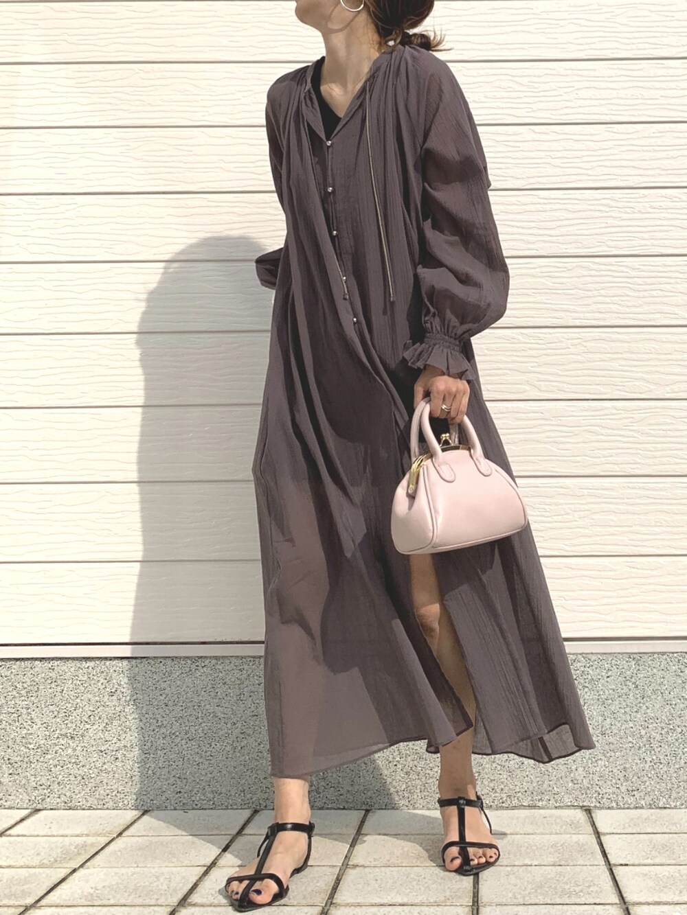 ピンク系のショルダーバッグ、ブラウン系のワンピースを着用したレディースの春コーディネートの2枚目の写真