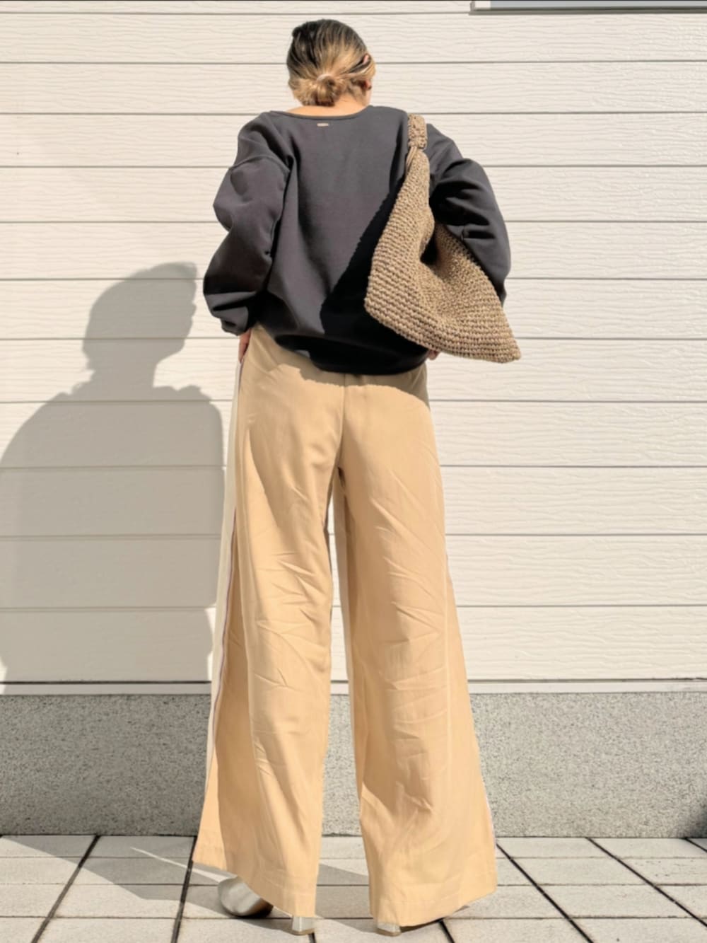 グレー系のTシャツ/カットソー、ベージュ系のトートバッグ、ホワイト系のその他パンツを着用したレディースの冬コーディネートの4枚目の写真