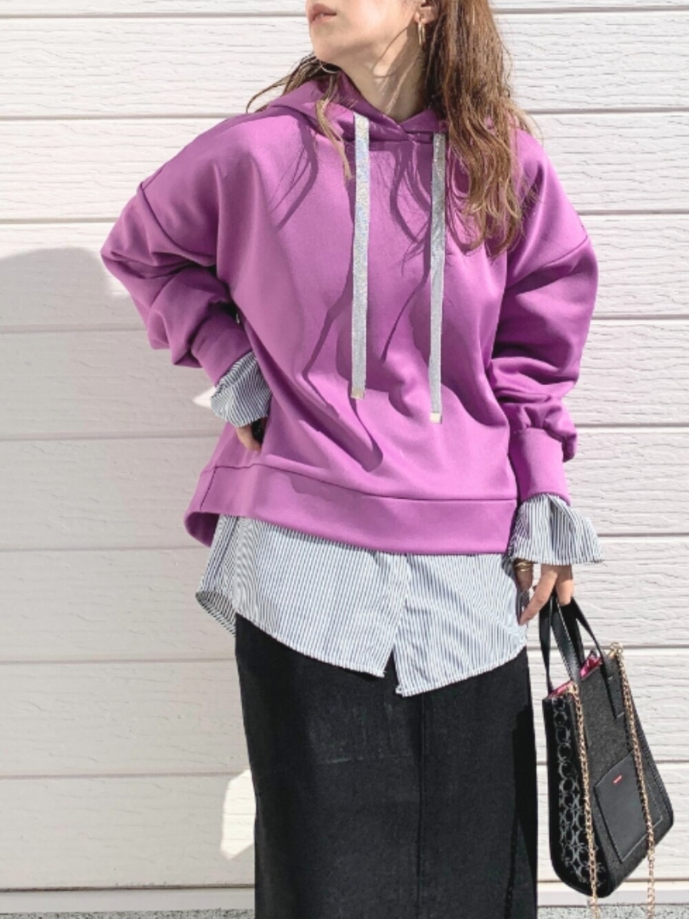 ブラック系のショルダーバッグ、ホワイト系のスニーカー、ブラック系のスカートを着用したレディースの秋コーディネートの4枚目の写真