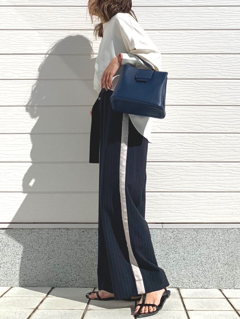 ブルー系のハンドバッグ、ホワイト系のシャツ/ブラウス、ブルー系のその他パンツを着用したレディースの春コーディネートの2枚目の写真
