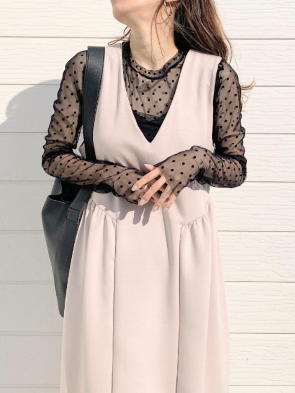 ブラック系のトートバッグ、ブラック系のTシャツ/カットソー、ベージュ系のジャンパースカートを着用したレディースの冬コーディネートの4枚目の写真