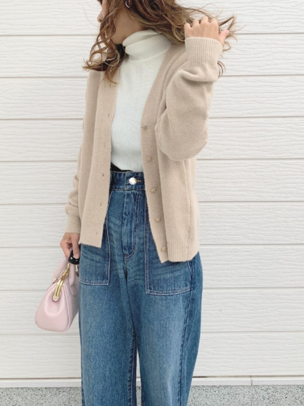 ブルー系のデニムパンツ、ピンク系のショルダーバッグ、ホワイト系のカーディガン/ボレロを着用したレディースの秋コーディネートの4枚目の写真
