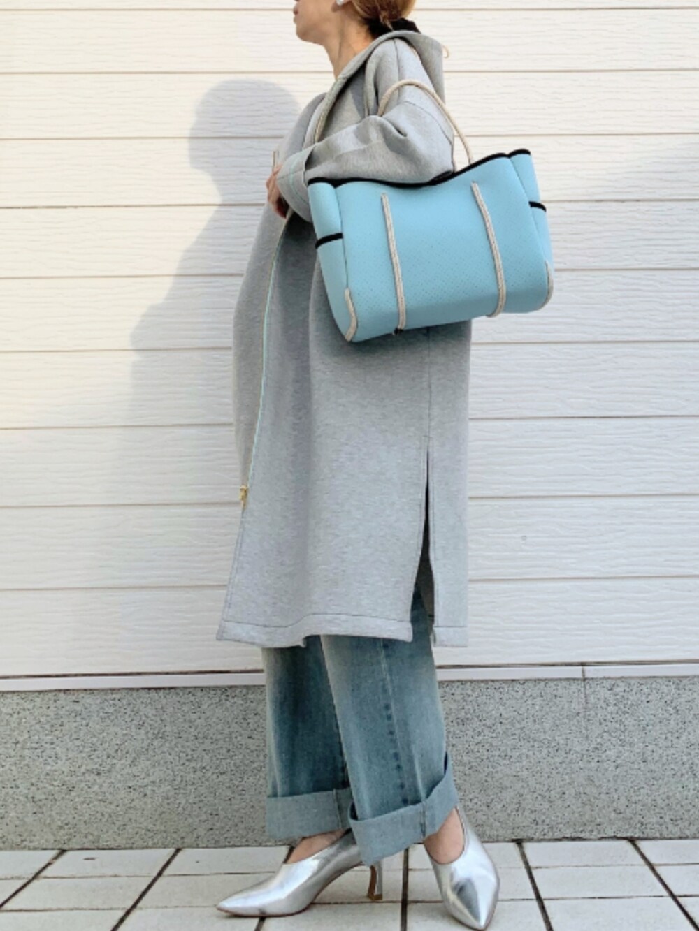 ブルー系のトートバッグ、ホワイト系のTシャツ/カットソー、グレー系のその他アウターを着用したレディースの冬コーディネートの2枚目の写真
