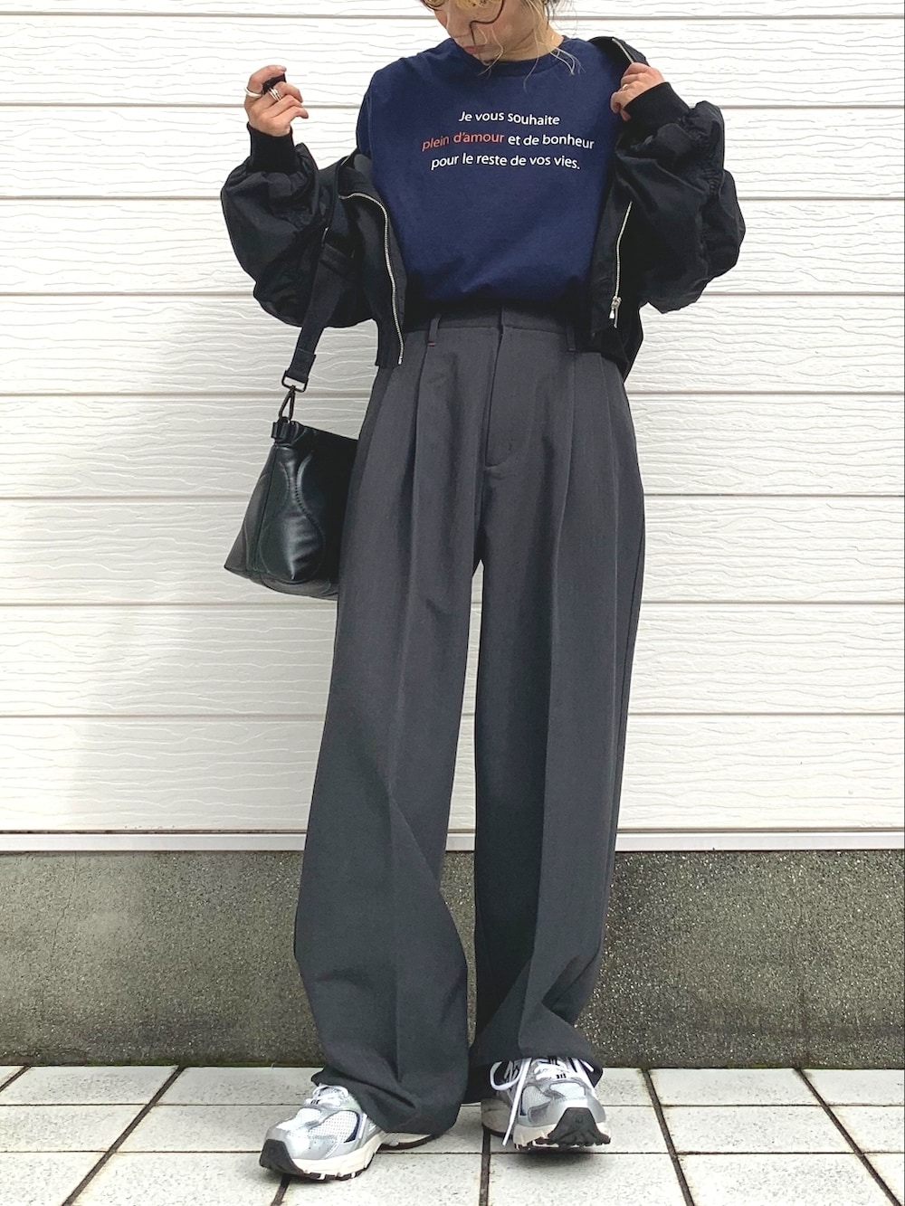 ブラック系のブルゾン、ブルー系のTシャツ/カットソー、シルバー系のスニーカーを着用したレディースの秋コーディネートの2枚目の写真