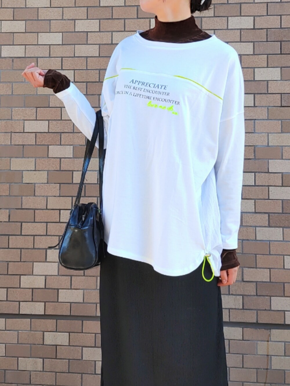 ホワイト系のスニーカー、ブラウン系のTシャツ/カットソー、ホワイト系のTシャツ/カットソーを着用したレディースの冬コーディネートの4枚目の写真