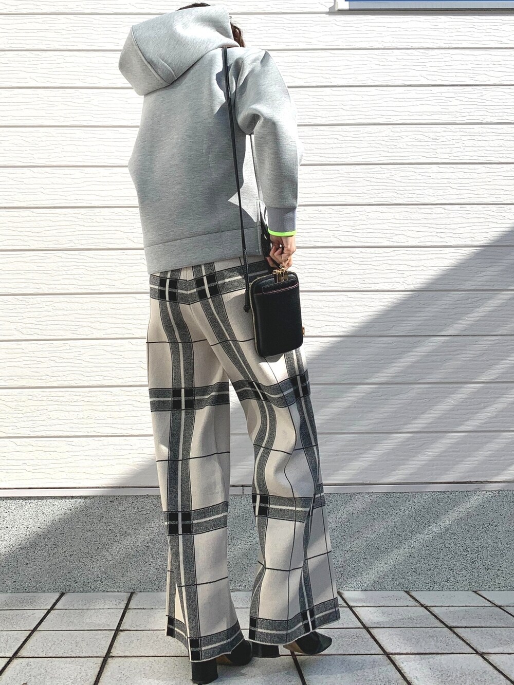 ブラック系のショルダーバッグ、グレー系のパーカー、ホワイト系のその他パンツを着用したレディースの冬コーディネートの3枚目の写真