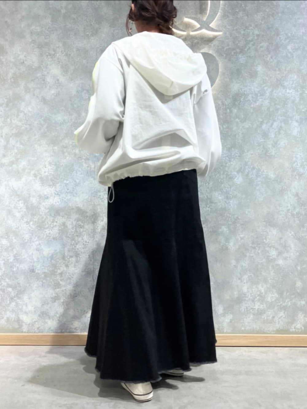 ブルー系のデニムスカート、グリーン系のTシャツ/カットソー、ホワイト系のパーカーを着用したレディースの春コーディネートの3枚目の写真