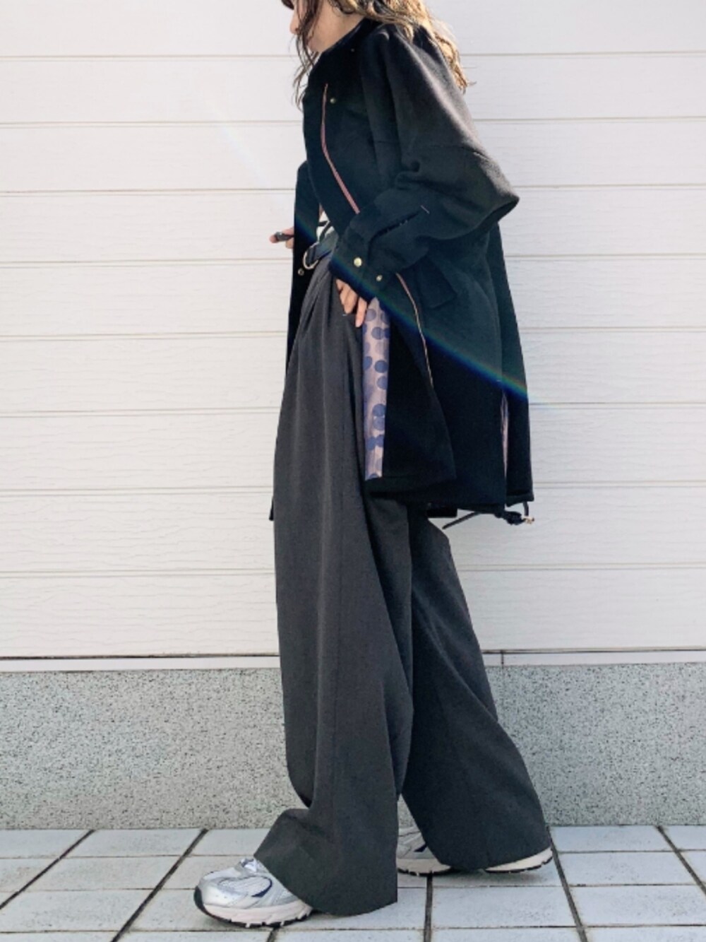 グレー系のその他パンツ、シルバー系のスニーカー、ブラック系のショルダーバッグを着用したレディースの秋コーディネートの2枚目の写真
