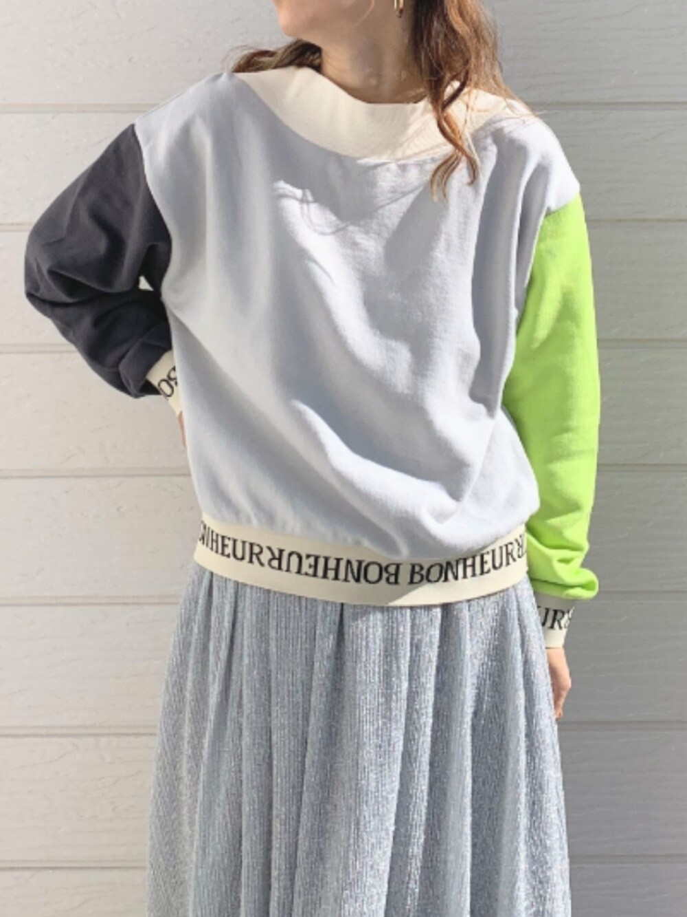 シルバー系のスカート、ホワイト系のスニーカー、グレー系のスウェットを着用したレディースの冬コーディネートの4枚目の写真