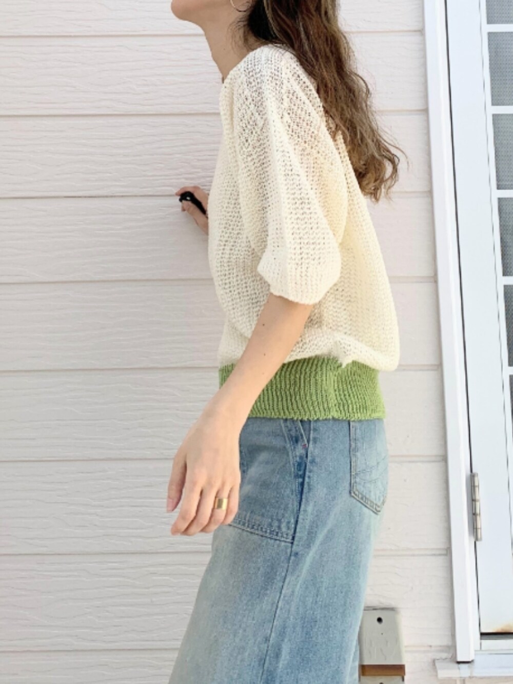 ブルー系のデニムパンツ、ホワイト系のキャミソール、ホワイト系のニット/セーターを着用したレディースの春コーディネートの3枚目の写真