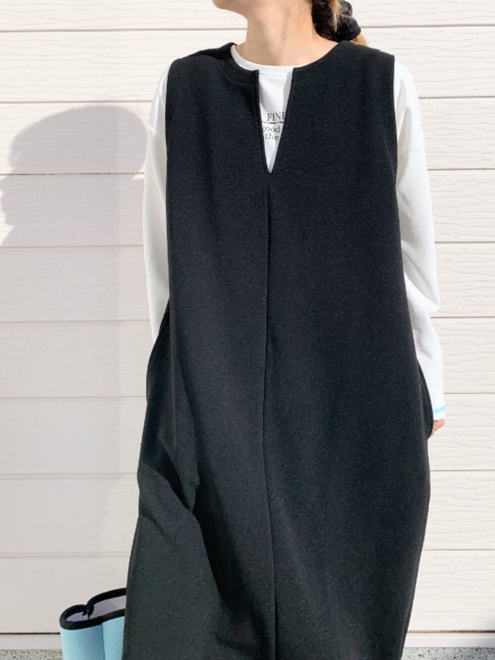 ブルー系のトートバッグ、ブラック系のワンピース、ホワイト系のTシャツ/カットソーを着用したレディースの冬コーディネートの4枚目の写真