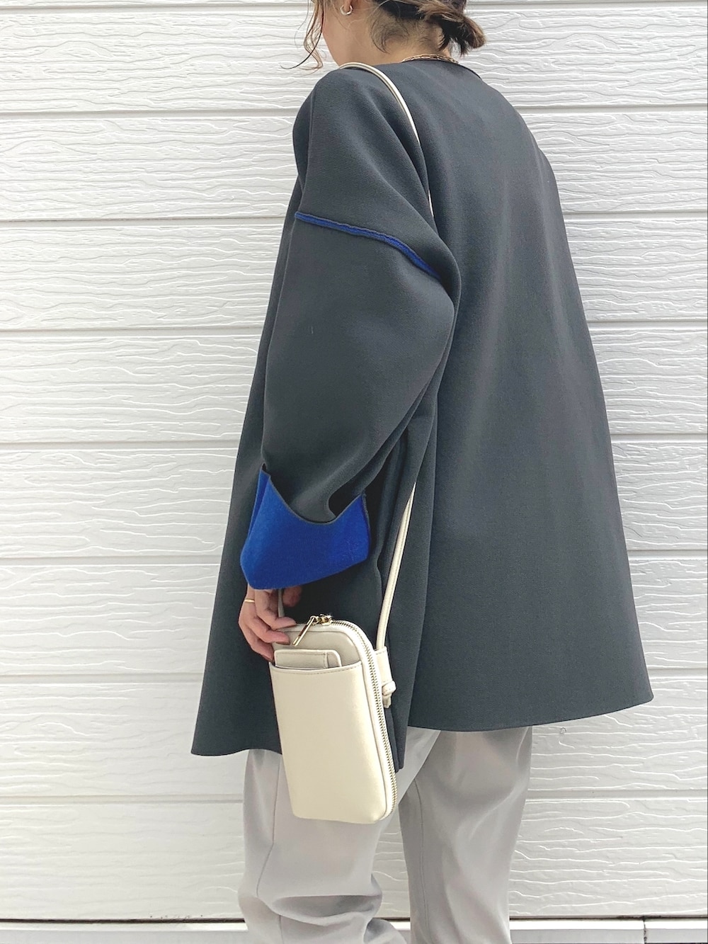 シルバー系のスニーカー、ホワイト系のその他パンツ、ブラック系のショルダーバッグを着用したレディースの秋コーディネートの3枚目の写真