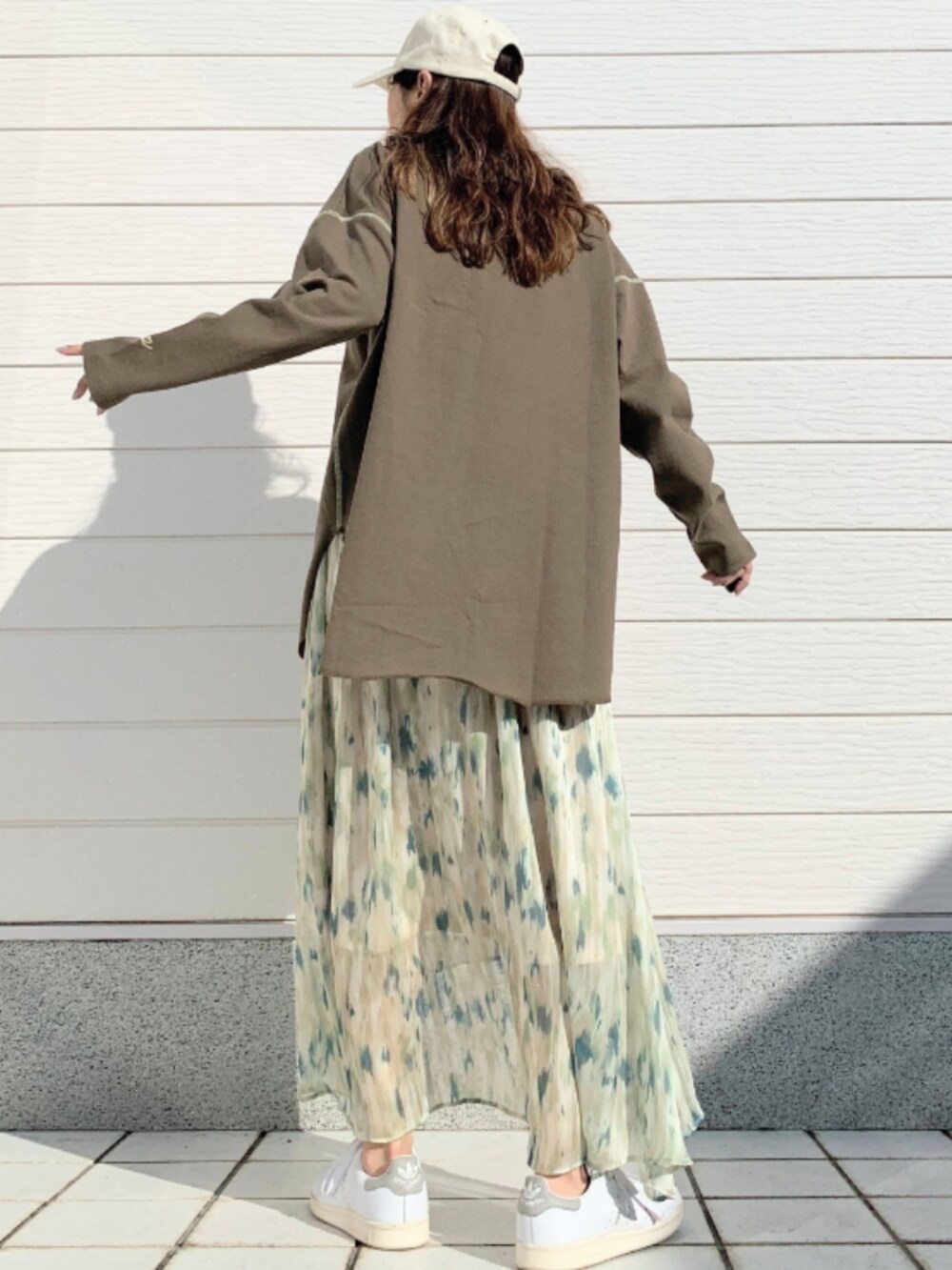 グリーン系のスカート、グリーン系のTシャツ/カットソー、ホワイト系のスニーカーを着用したレディースの冬コーディネートの3枚目の写真
