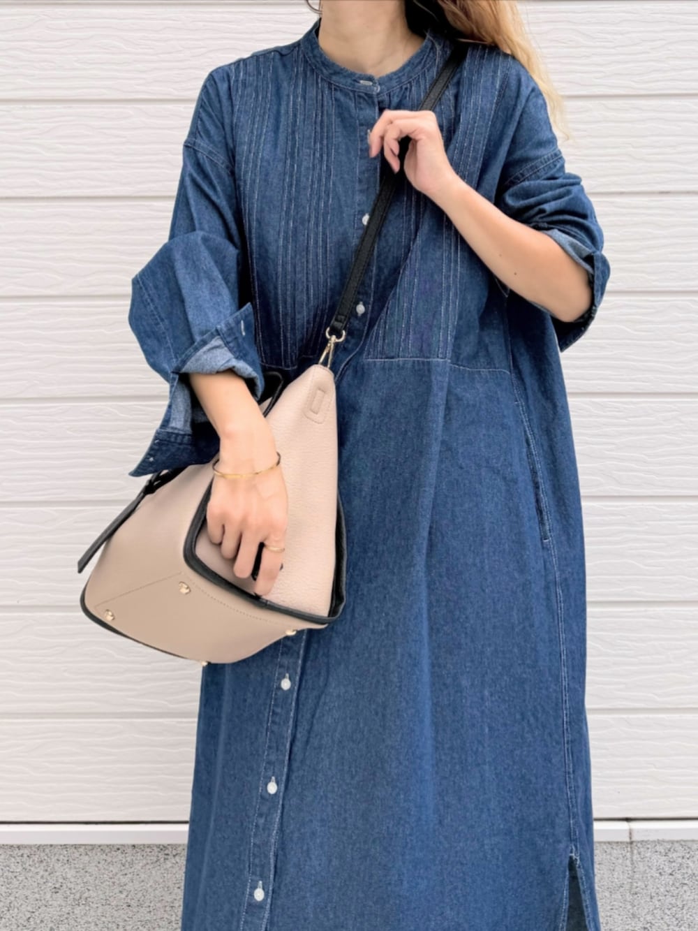 ブラック系のサンダル、ブルー系のシャツワンピース、ベージュ系のハンドバッグを着用したレディースの夏コーディネートの5枚目の写真