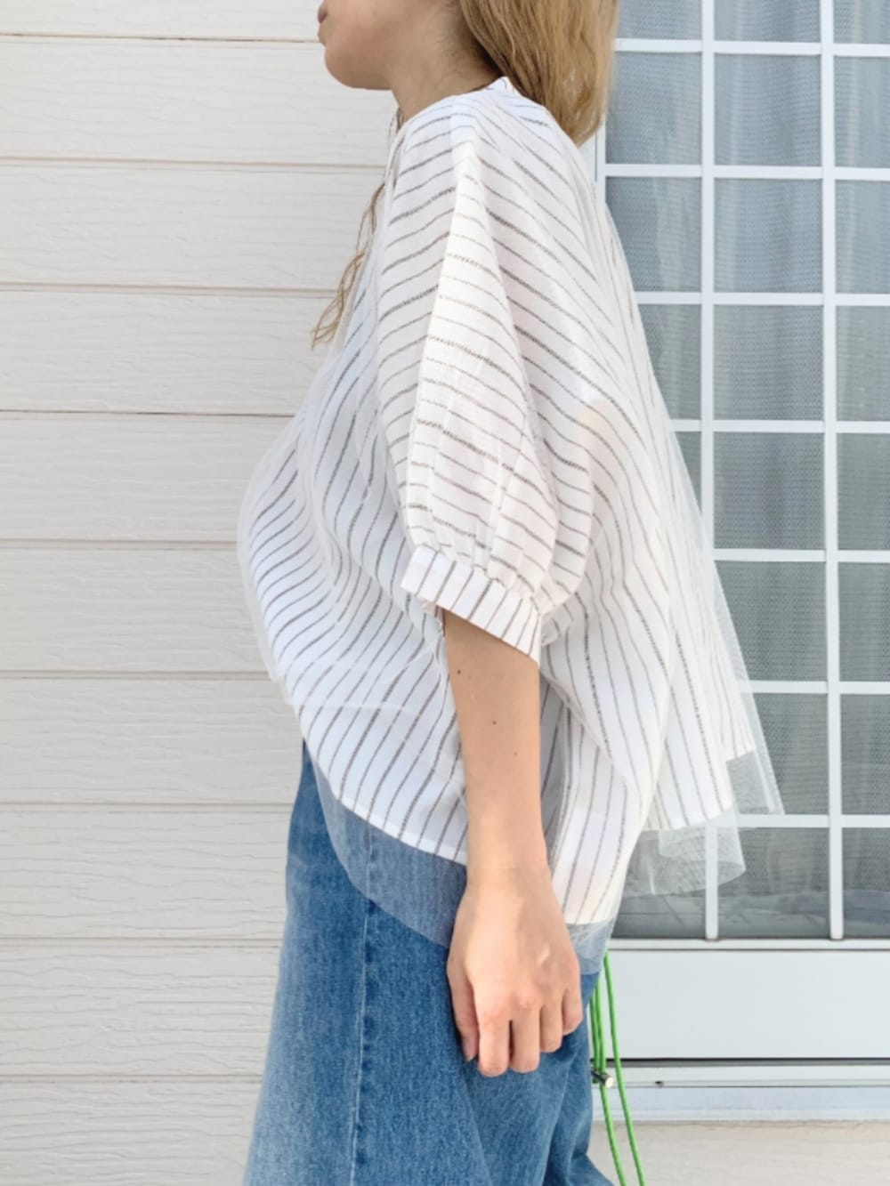 ブルー系のデニムパンツ、ホワイト系のシャツ/ブラウス、グリーン系のカードケースを着用したレディースの春コーディネートの3枚目の写真