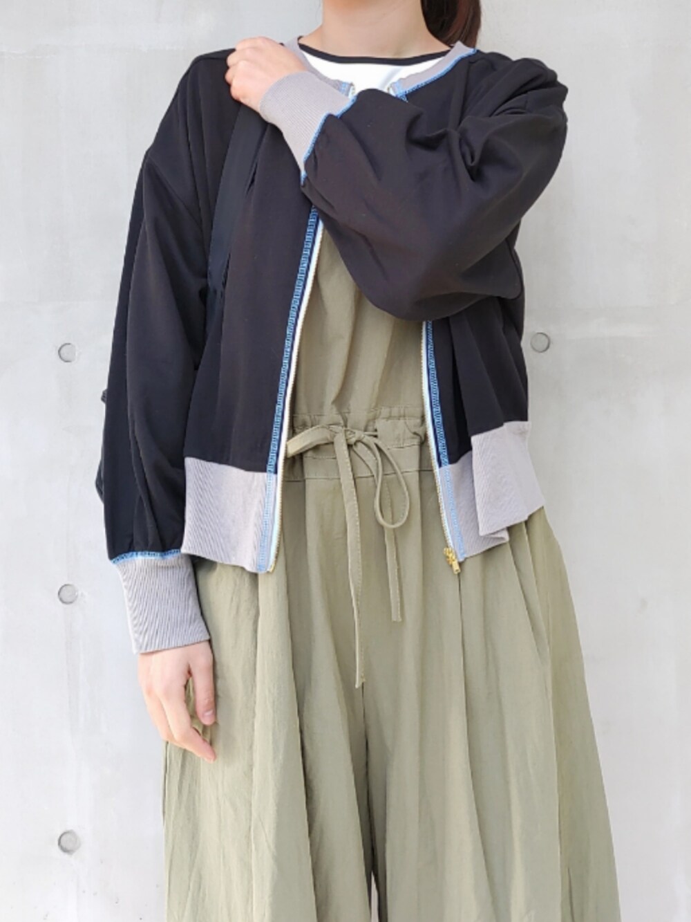 ブラック系のスニーカー、ブラック系のバックパック/リュック、グリーン系のサロペット/オーバーオールを着用したレディースの冬コーディネートの4枚目の写真