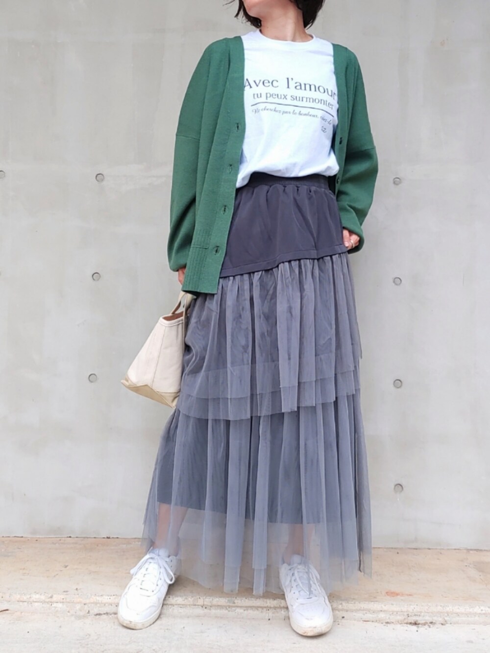 ホワイト系のTシャツ/カットソー、グリーン系のカーディガン/ボレロ、ベージュ系のトートバッグを着用したレディースの秋コーディネートの2枚目の写真