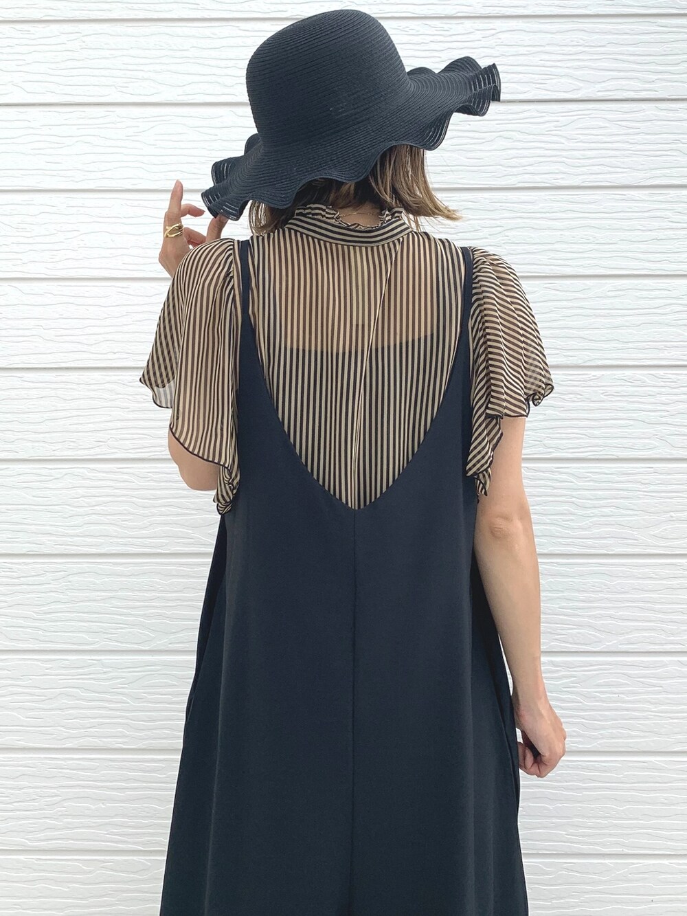 ブラック系のサロペット/オーバーオール、ブラック系のサンダル、ブラウン系のシャツ/ブラウスを着用したレディースの夏コーディネートの2枚目の写真