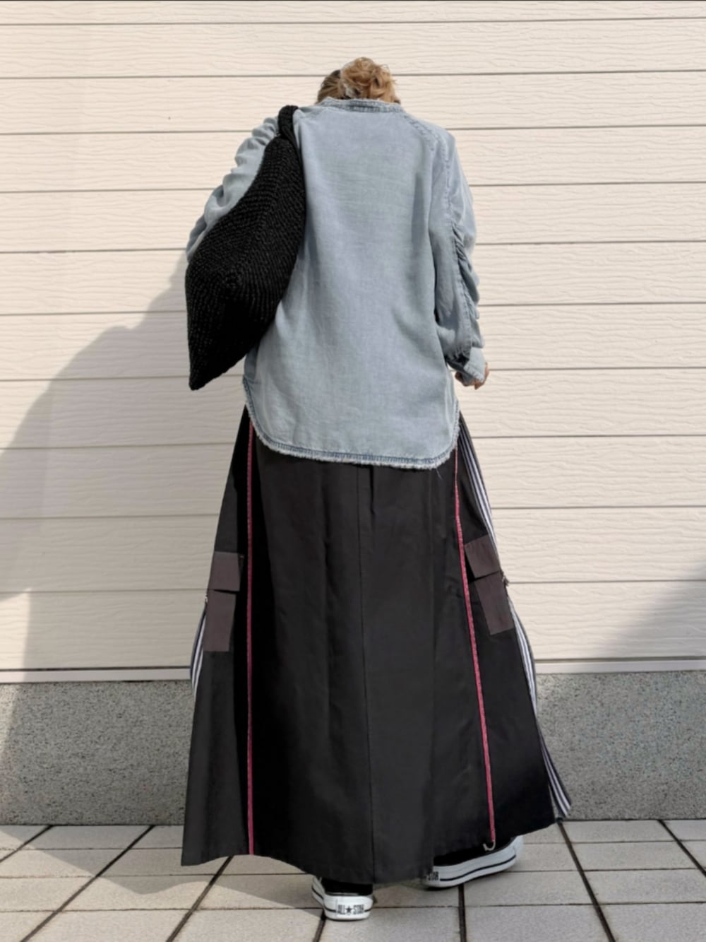 グレー系のスカート、ブラック系のスニーカー、ブルー系のシャツ/ブラウスを着用したレディースの冬コーディネートの3枚目の写真