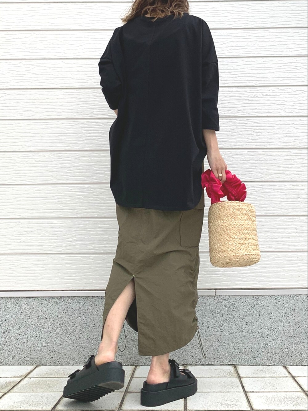 ピンク系のかごバッグ、グリーン系のスカート、ブラック系のサンダルを着用したレディースの春コーディネートの3枚目の写真
