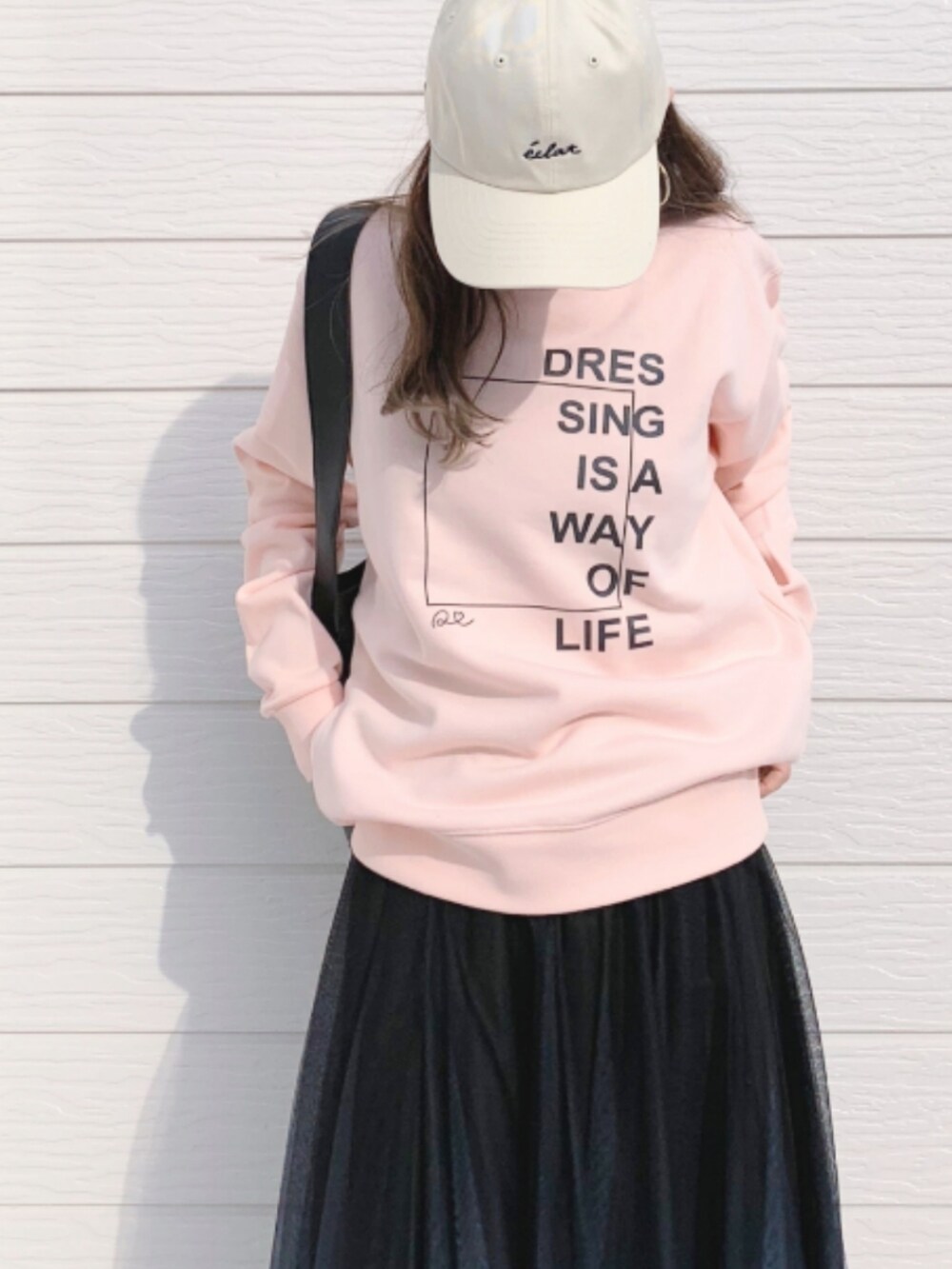 ブラック系のスカート、ホワイト系のスニーカー、ピンク系のスウェットを着用したレディースの春コーディネートの4枚目の写真