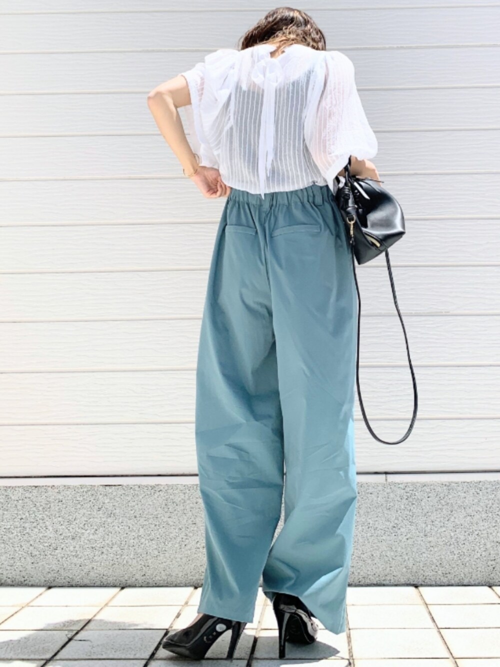 ホワイト系のシャツ/ブラウス、ブルー系のその他パンツ、ブラック系のハンドバッグを着用したレディースの春コーディネートの3枚目の写真