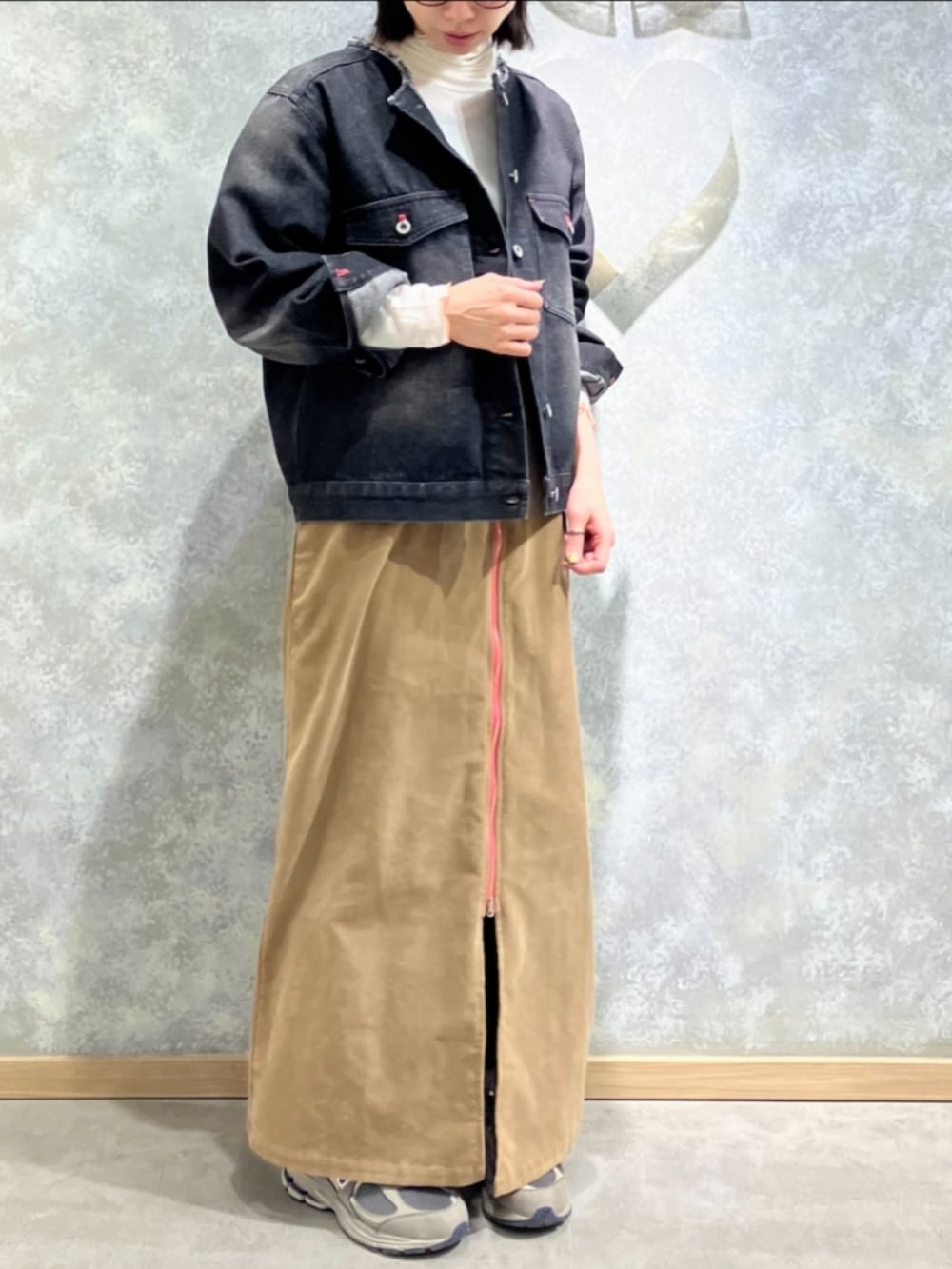 ブラック系のデニムジャケット、ベージュ系のワンピース、ホワイト系のTシャツ/カットソーを着用したレディースの冬コーディネートの2枚目の写真