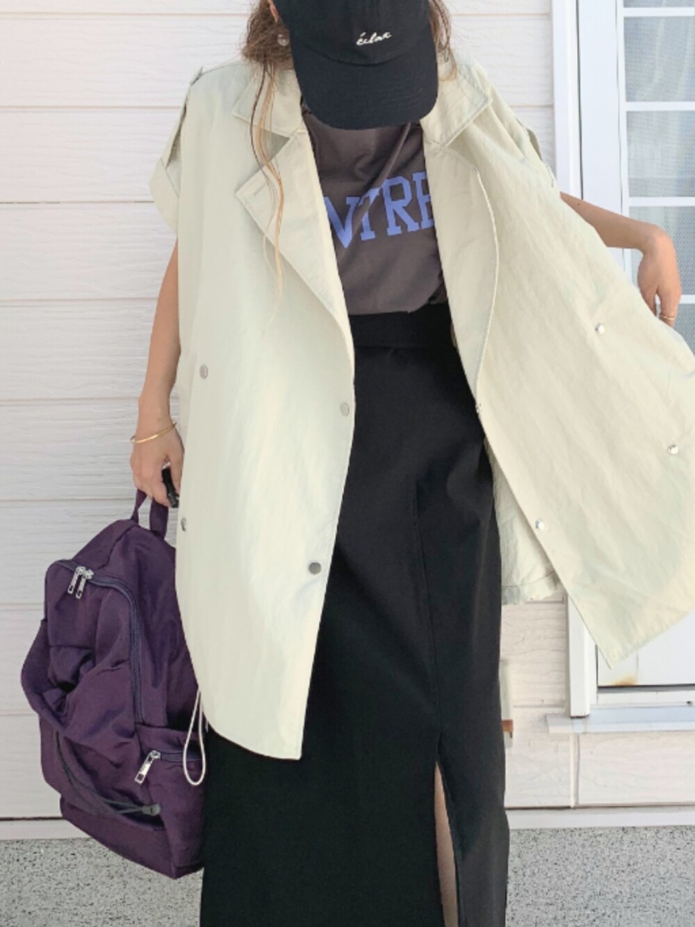 グレー系のTシャツ/カットソー、ブラック系のスカート、パープル系のバックパック/リュックを着用したレディースの夏コーディネートの4枚目の写真