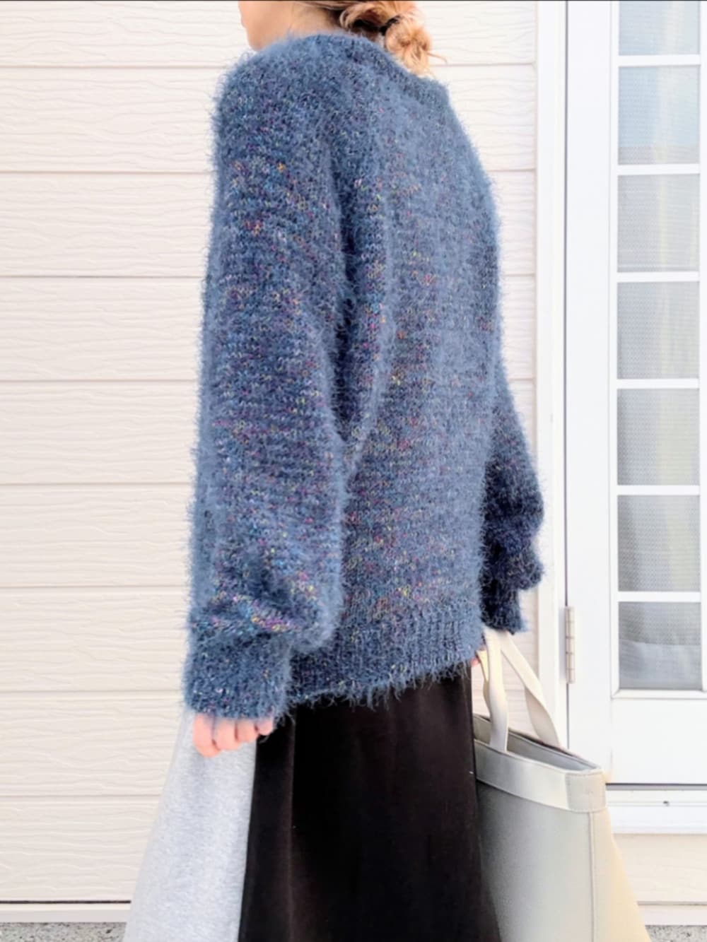 グレー系のトートバッグ、ブラック系のブーツ、グレー系のスカートを着用したレディースの秋コーディネートの5枚目の写真