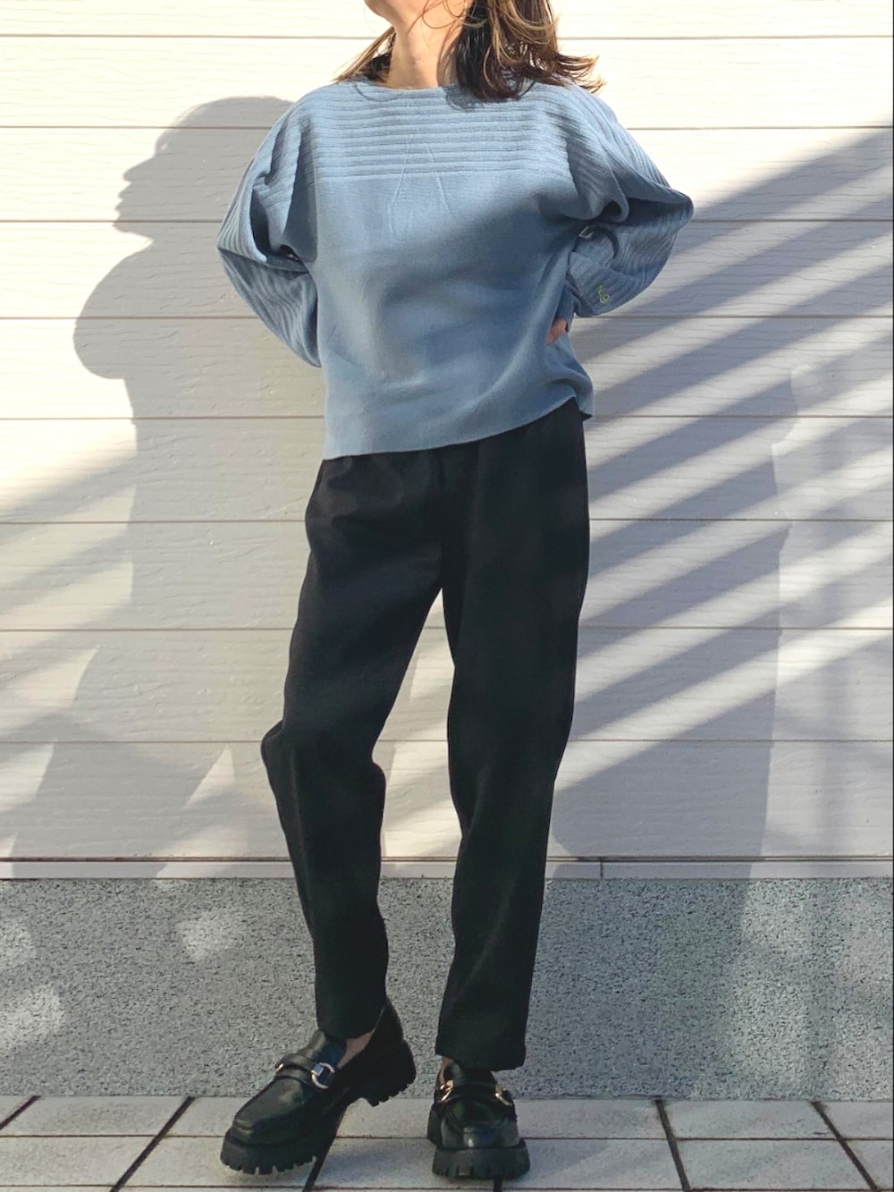 ブラック系のその他パンツ、ブラック系のローファー、ブルー系のニット/セーターを着用したレディースの冬コーディネートの5枚目の写真