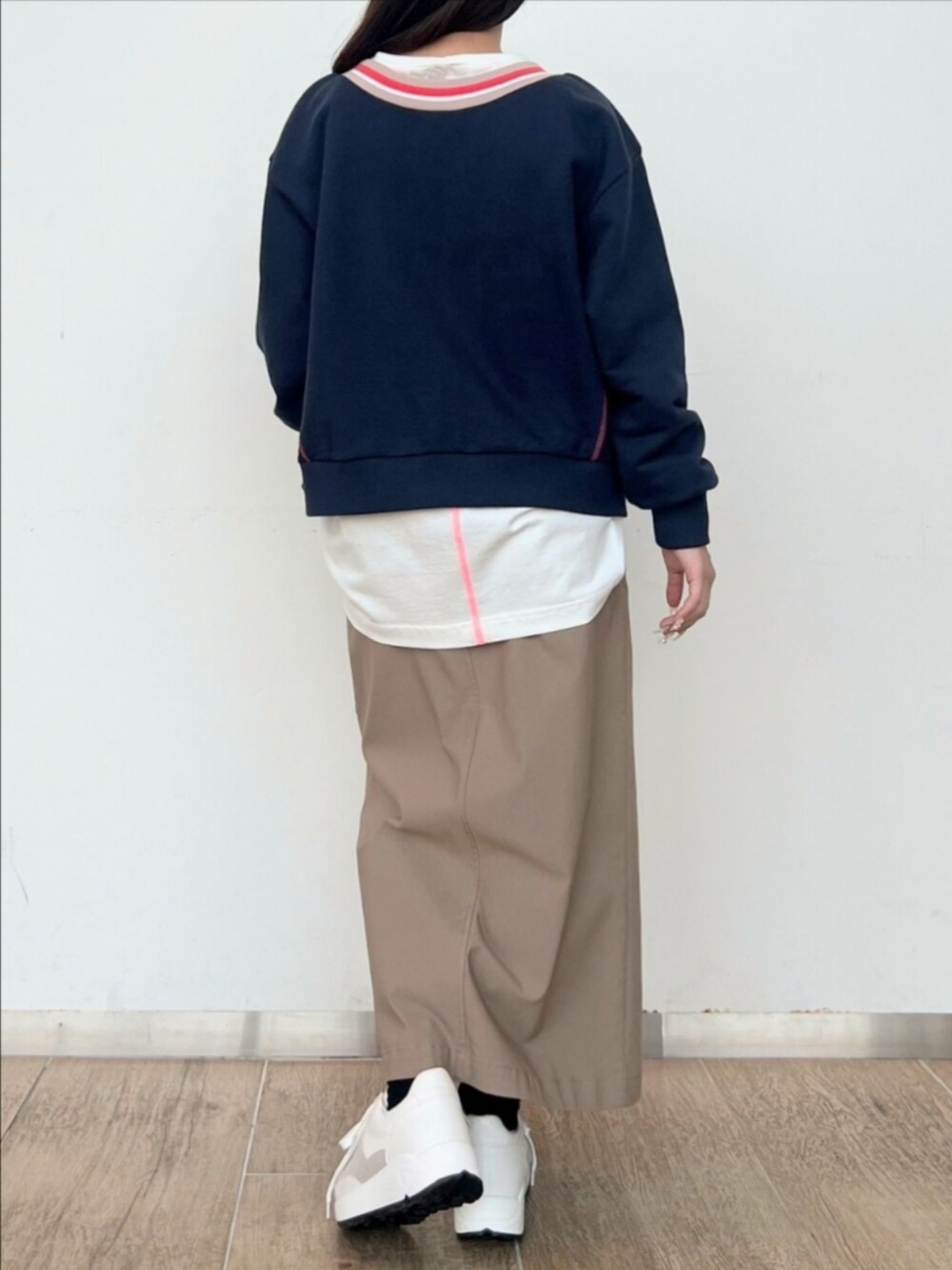 ベージュ系のスカート、ホワイト系のTシャツ/カットソー、ホワイト系のスニーカーを着用したレディースの冬コーディネートの5枚目の写真