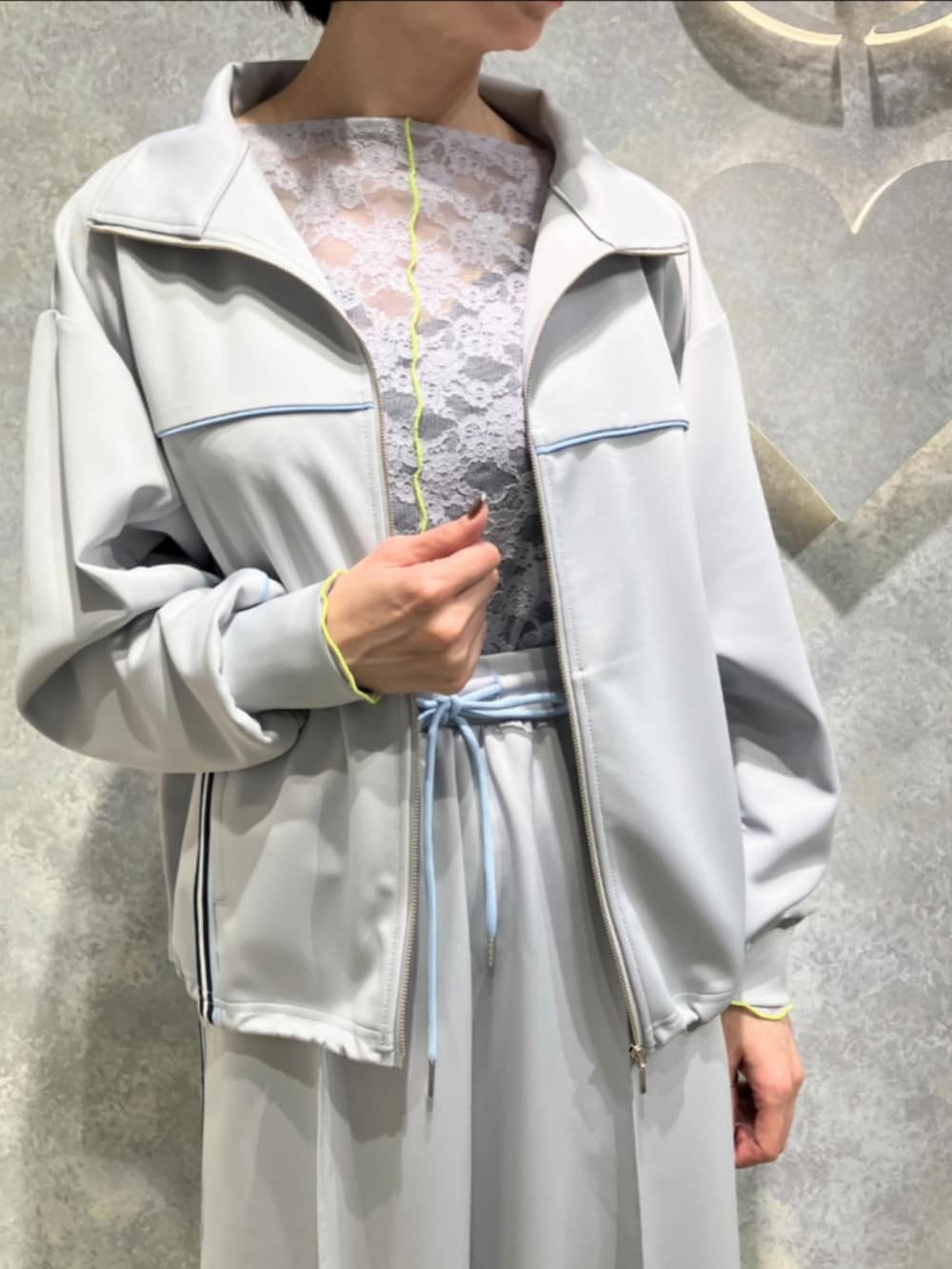 ホワイト系のブーツ、グレー系のその他アウター、グレー系のスカートを着用したレディースの春コーディネートの4枚目の写真