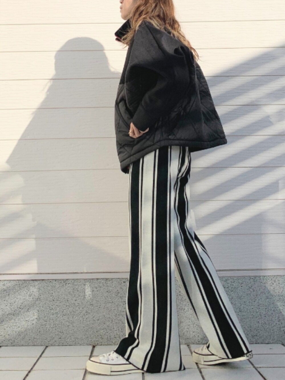 ブラック系のその他パンツ、ホワイト系のTシャツ/カットソー、ホワイト系のスニーカーを着用したレディースの冬コーディネートの2枚目の写真