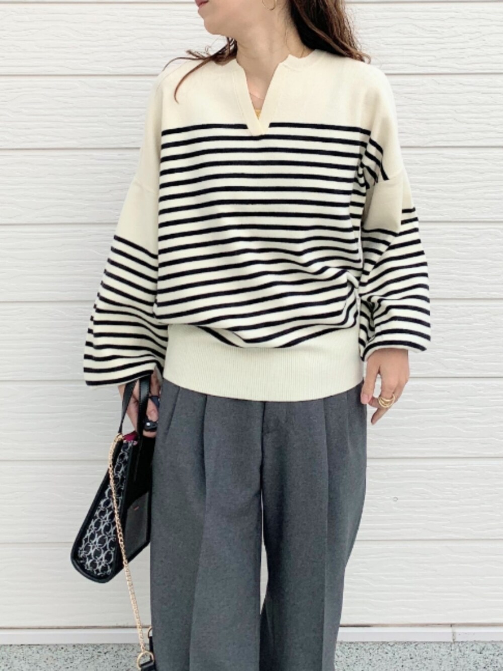 グレー系のその他パンツ、ホワイト系のスニーカー、ブラック系のショルダーバッグを着用したレディースの冬コーディネートの3枚目の写真