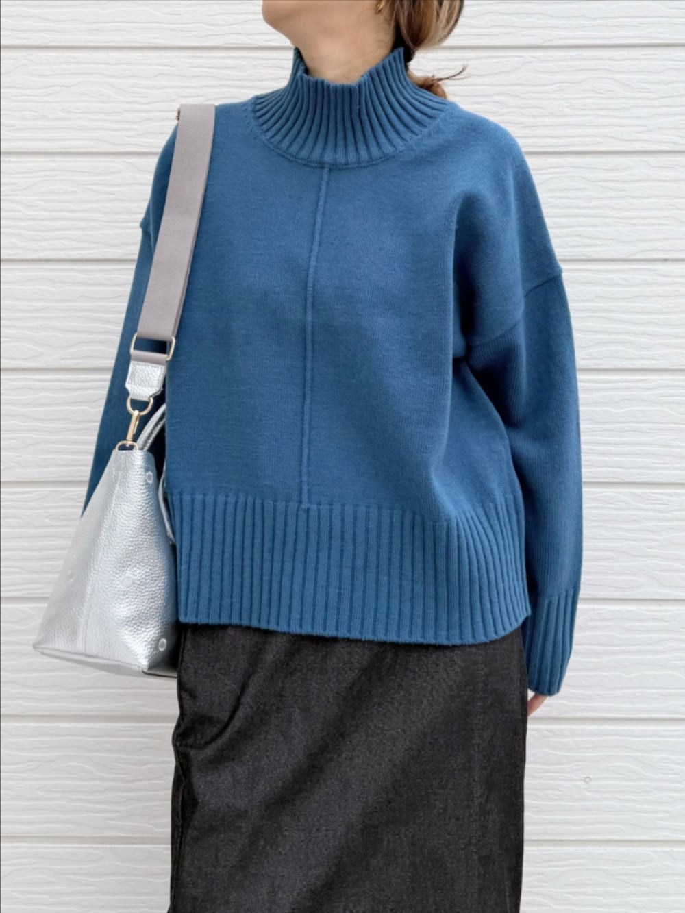 グレー系のスカート、ブラック系のブーツ、シルバー系のトートバッグを着用したレディースの冬コーディネートの4枚目の写真