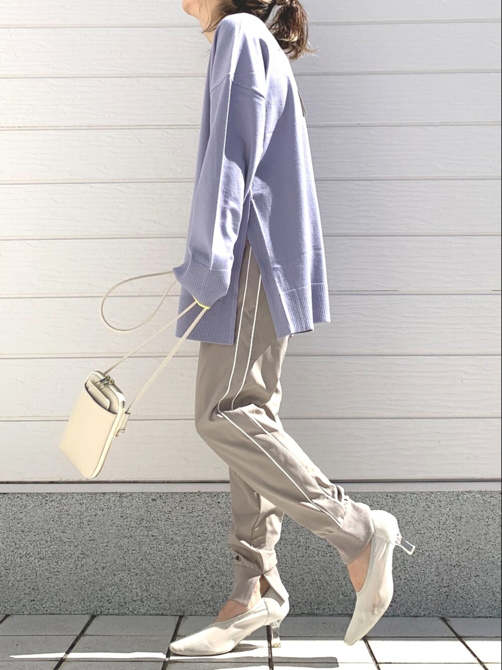 ホワイト系のデニムジャケット、パープル系のニット/セーター、ホワイト系のショルダーバッグを着用したレディースの冬コーディネートの3枚目の写真