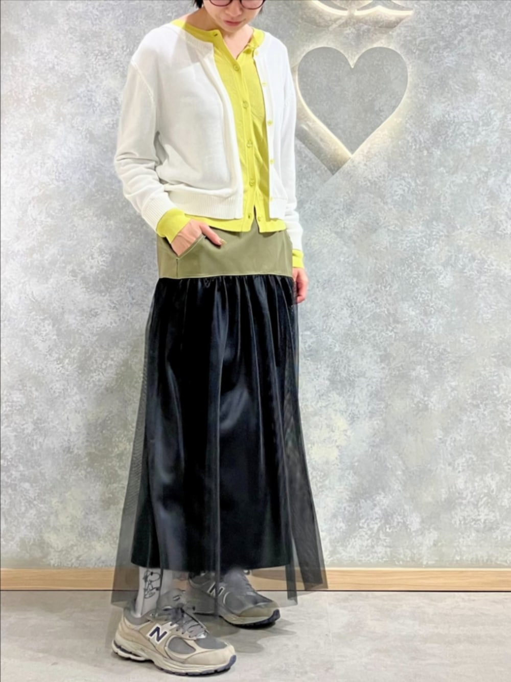 ブラック系のスカート、ホワイト系のカーディガン/ボレロを着用したレディースの春コーディネートの2枚目の写真