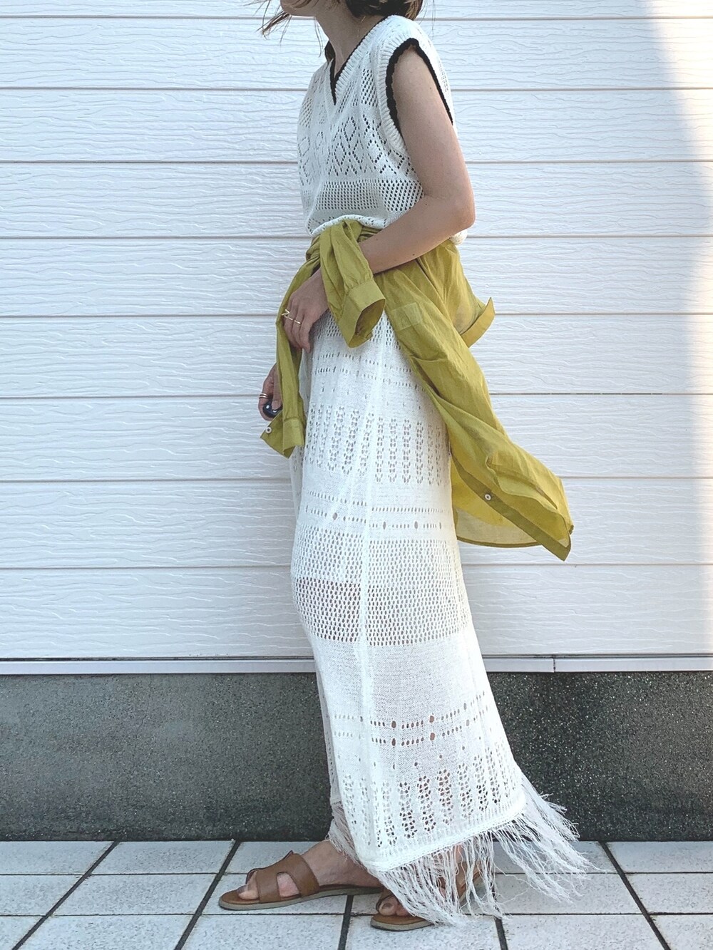 イエロー系のサンダル、ホワイト系のワンピース、イエロー系のシャツ/ブラウスを着用したレディースの夏コーディネートの2枚目の写真