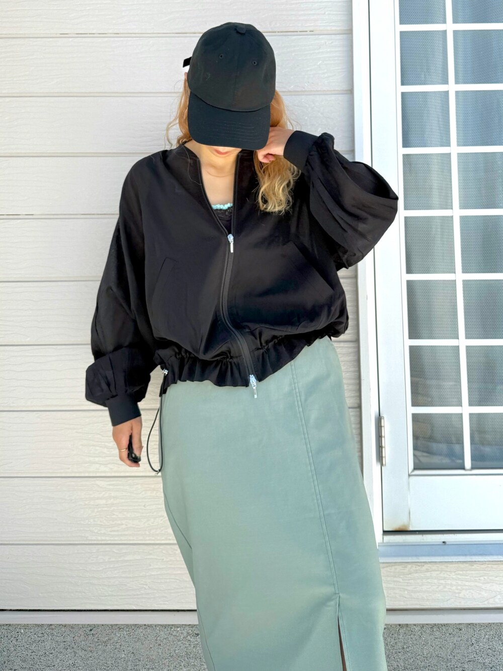 グレー系のタンクトップ、ブラック系のブルゾン、グリーン系のスカートを着用したレディースの夏コーディネートの2枚目の写真