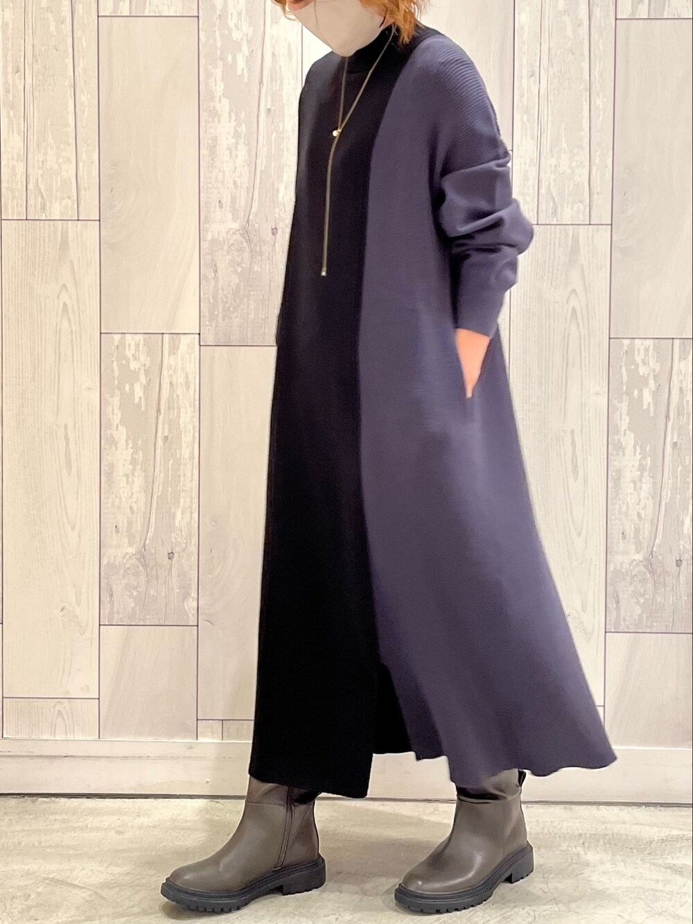 グレー系のブーツ、シルバー系のショルダーバッグ、ブルー系のワンピースを着用したレディースの秋コーディネートの2枚目の写真