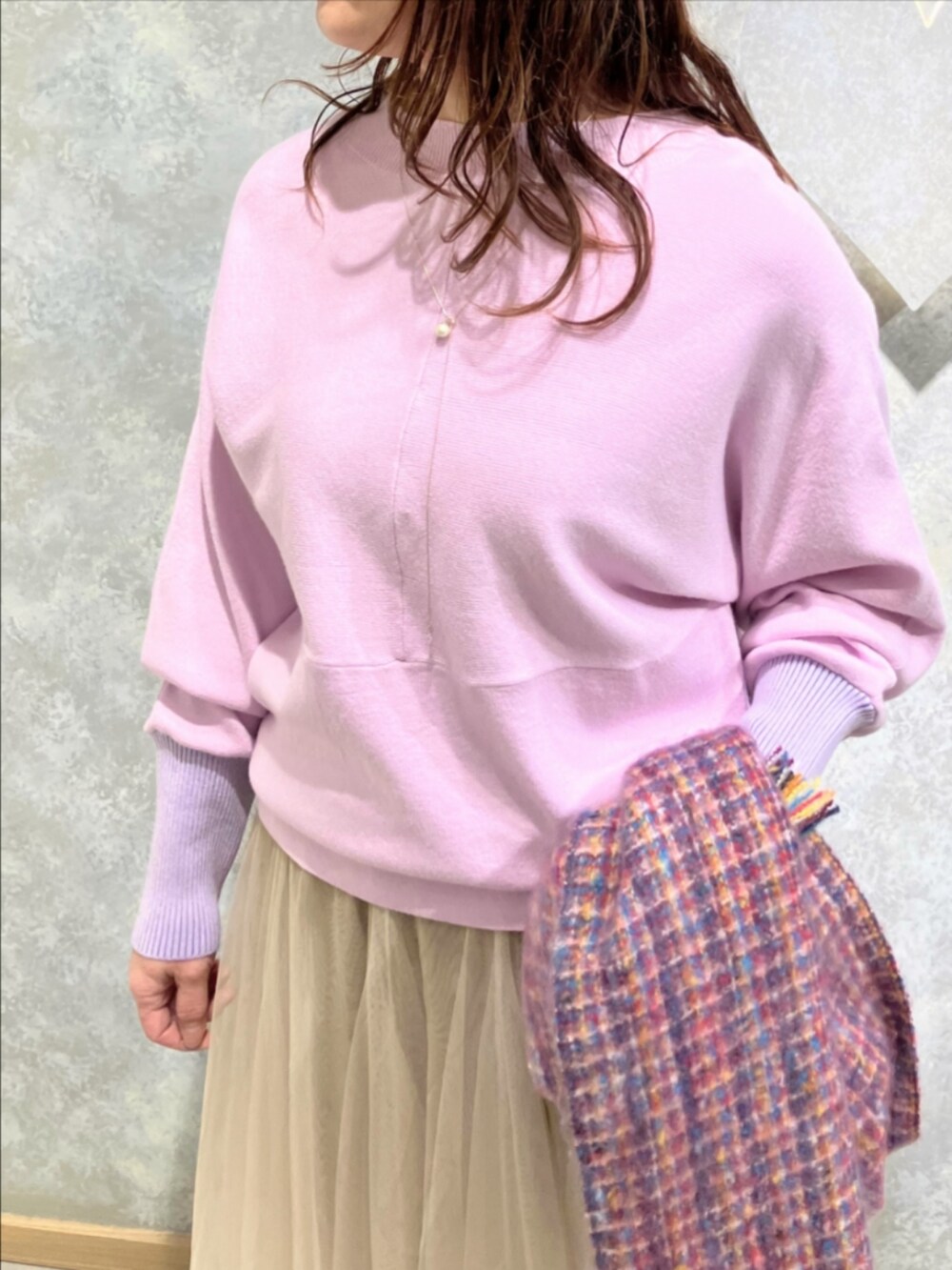 ゴールド系のスカート、パープル系のニット/セーター、ピンク系のマフラーを着用したレディースの冬コーディネートの5枚目の写真