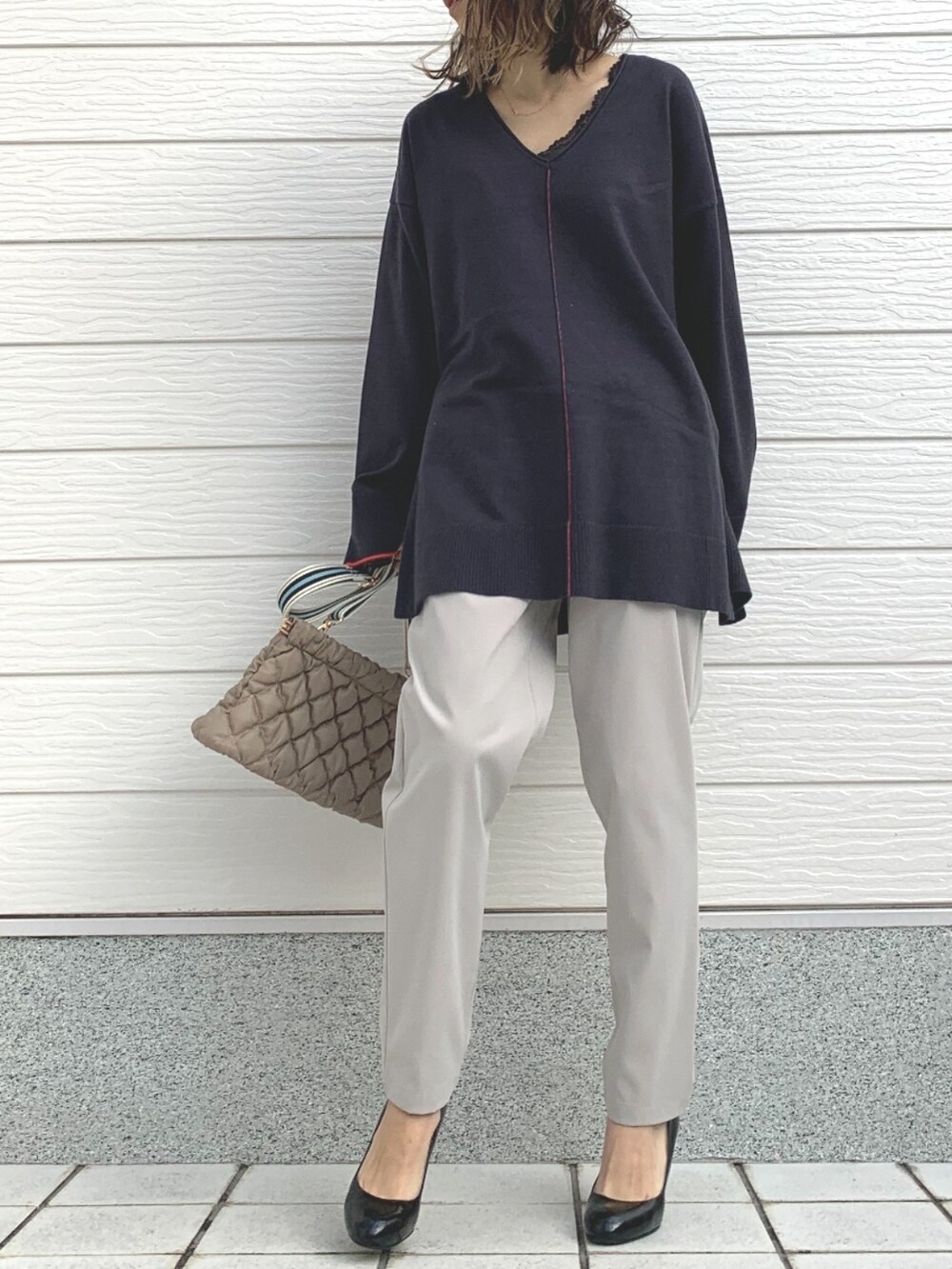 ホワイト系のその他パンツ、グレー系のニット/セーター、ベージュ系のショルダーバッグを着用したレディースの冬コーディネートの2枚目の写真